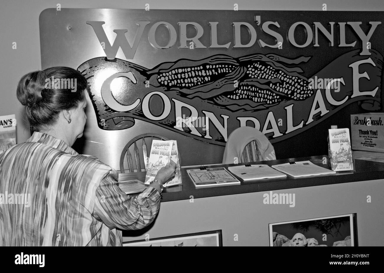 A Caucasian female tourist, 60 to 65 years old, looking at a brochure at the Corn Palace Convention & Visitors Bureau in Mitchell, South Dakota, USA. Stock Photo