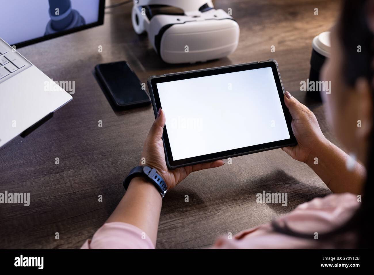 Holding tablet with blank screen, person working in tech office with VR headset, copy space Stock Photo