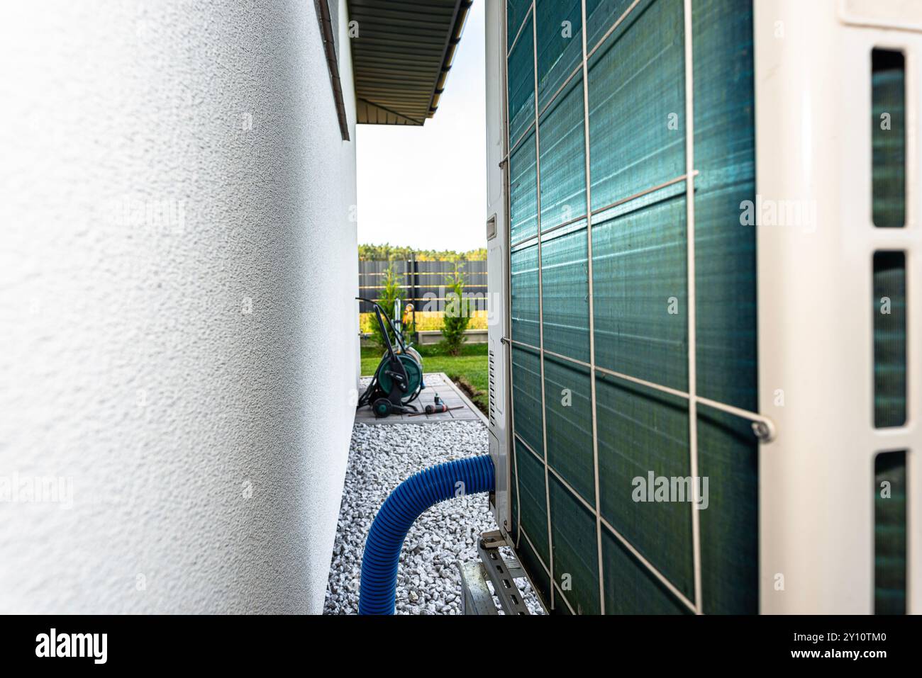 Two efficient outdoor heat pump units placed in front of the house. Stock Photo