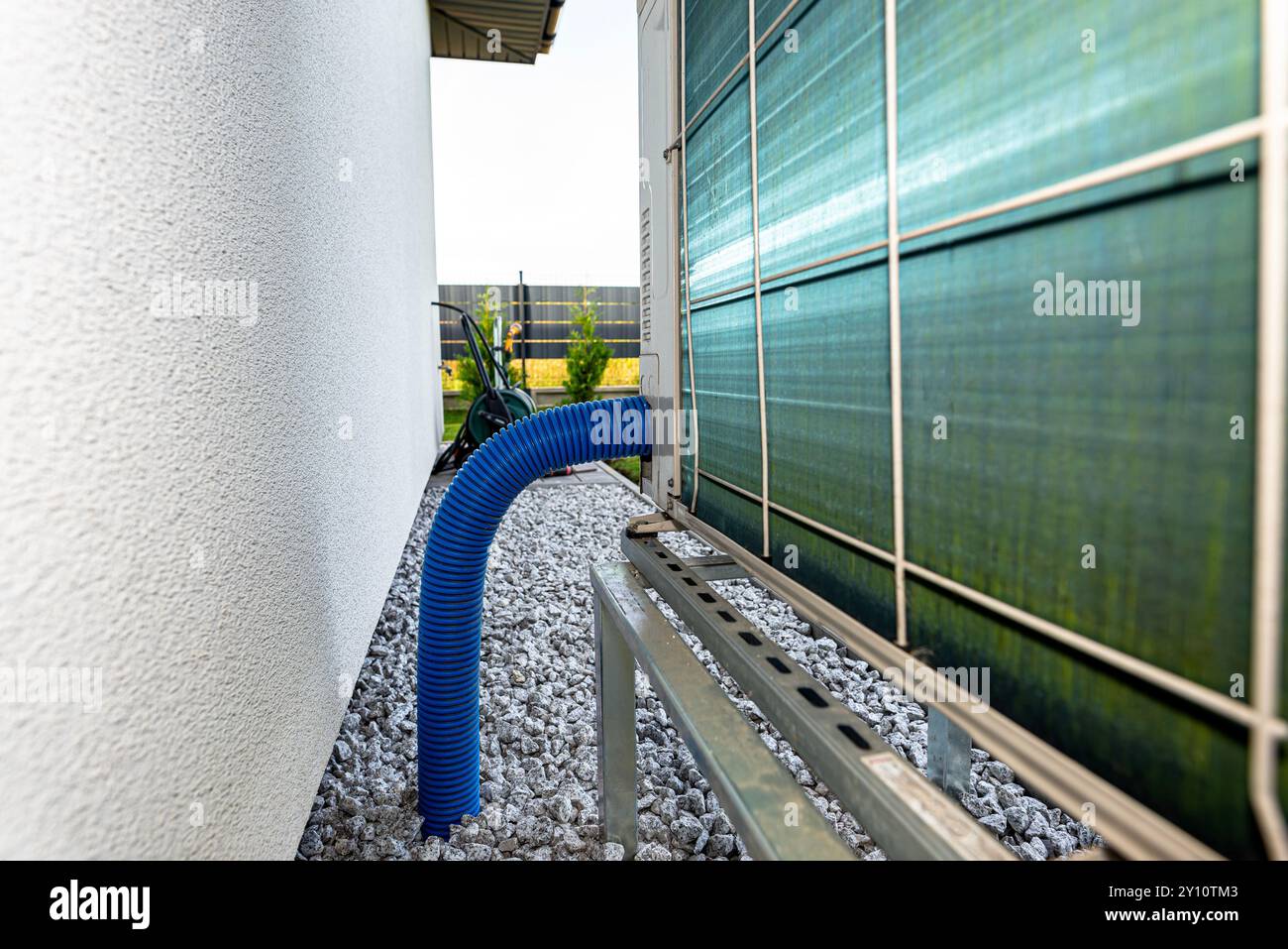 Two efficient outdoor heat pump units placed in front of the house. Stock Photo