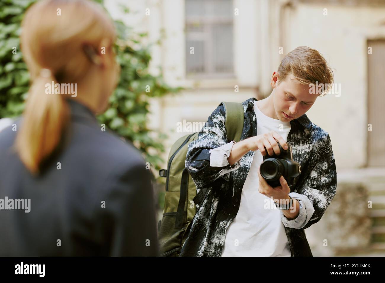 Young Photographer Adjusting Camera in Outdoor Setting Stock Photo