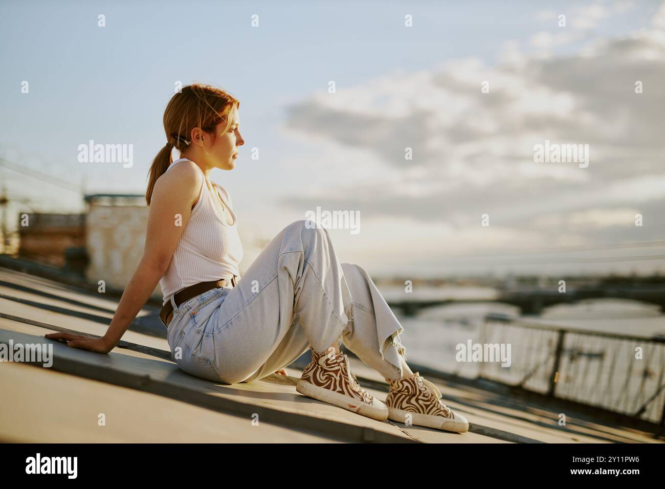 Relaxing on Rooftop Overlooking Cityscape at Sunset Stock Photo