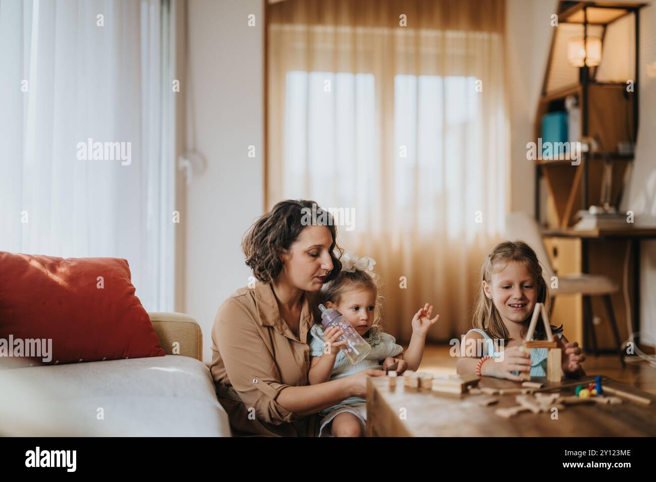 Mother and daughters enjoying creative playtime at home together Stock ...