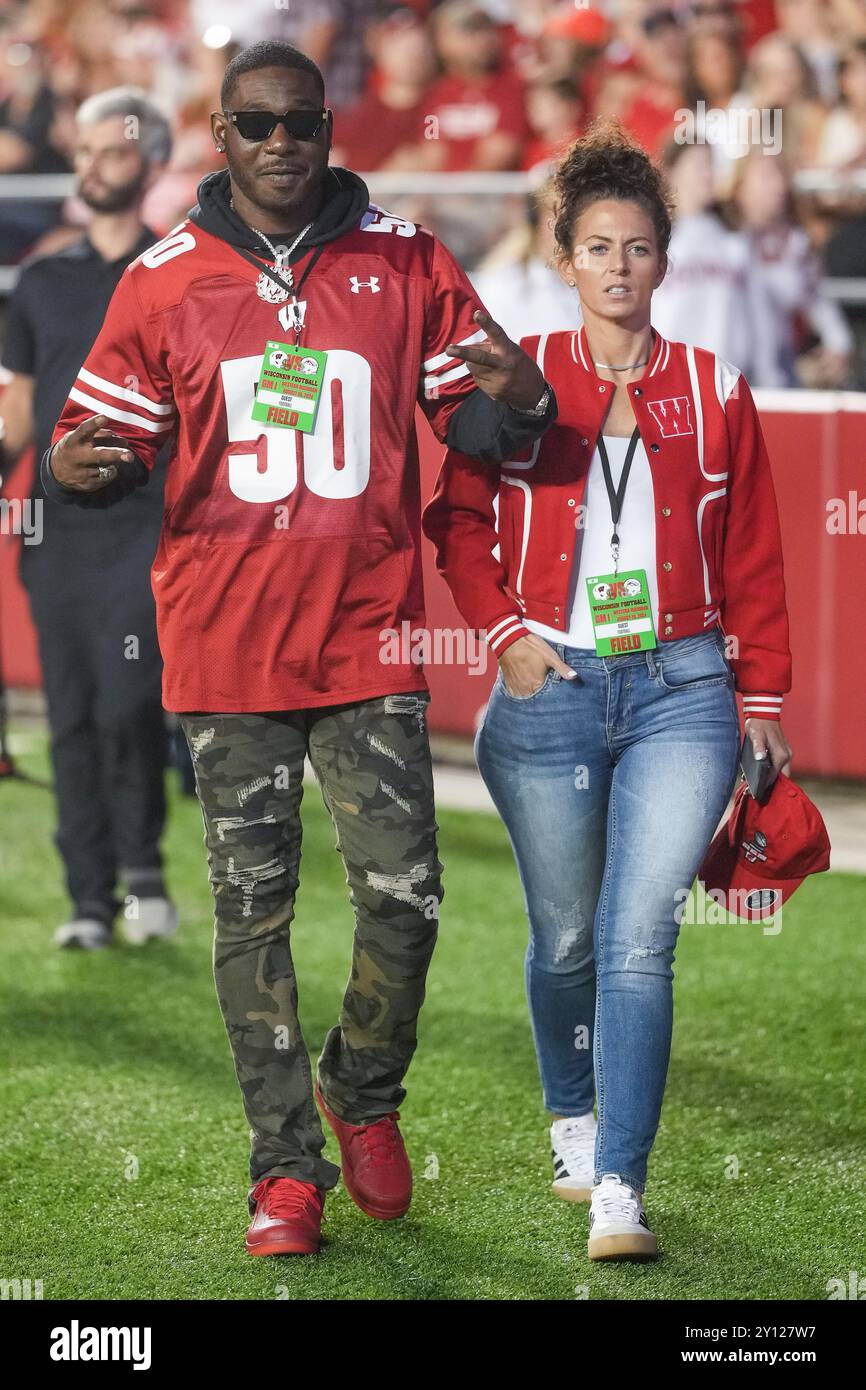 Former Wisconsin Badgers linebacker O'Brien Schofield (50) walks on the field with his wife Angela during a NCAA Football game between the Western Mic Stock Photo