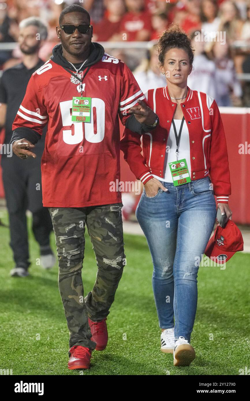 Former Wisconsin Badgers linebacker O'Brien Schofield (50) walks on the field with his wife Angela during a NCAA Football game between the Western Mic Stock Photo