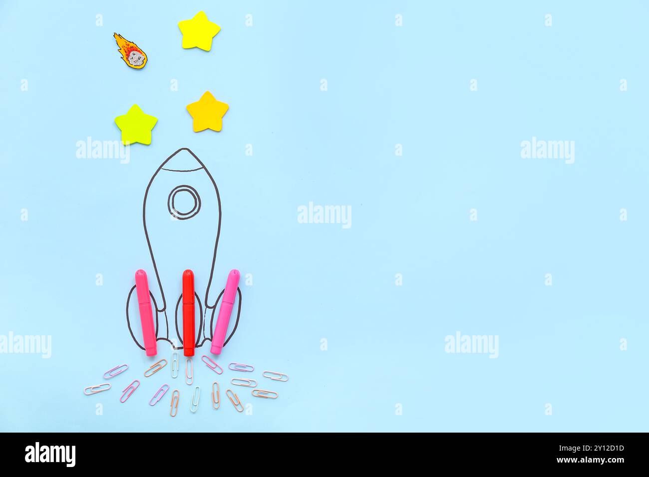 Creative composition with drawn rocket and different stationery on blue background Stock Photo