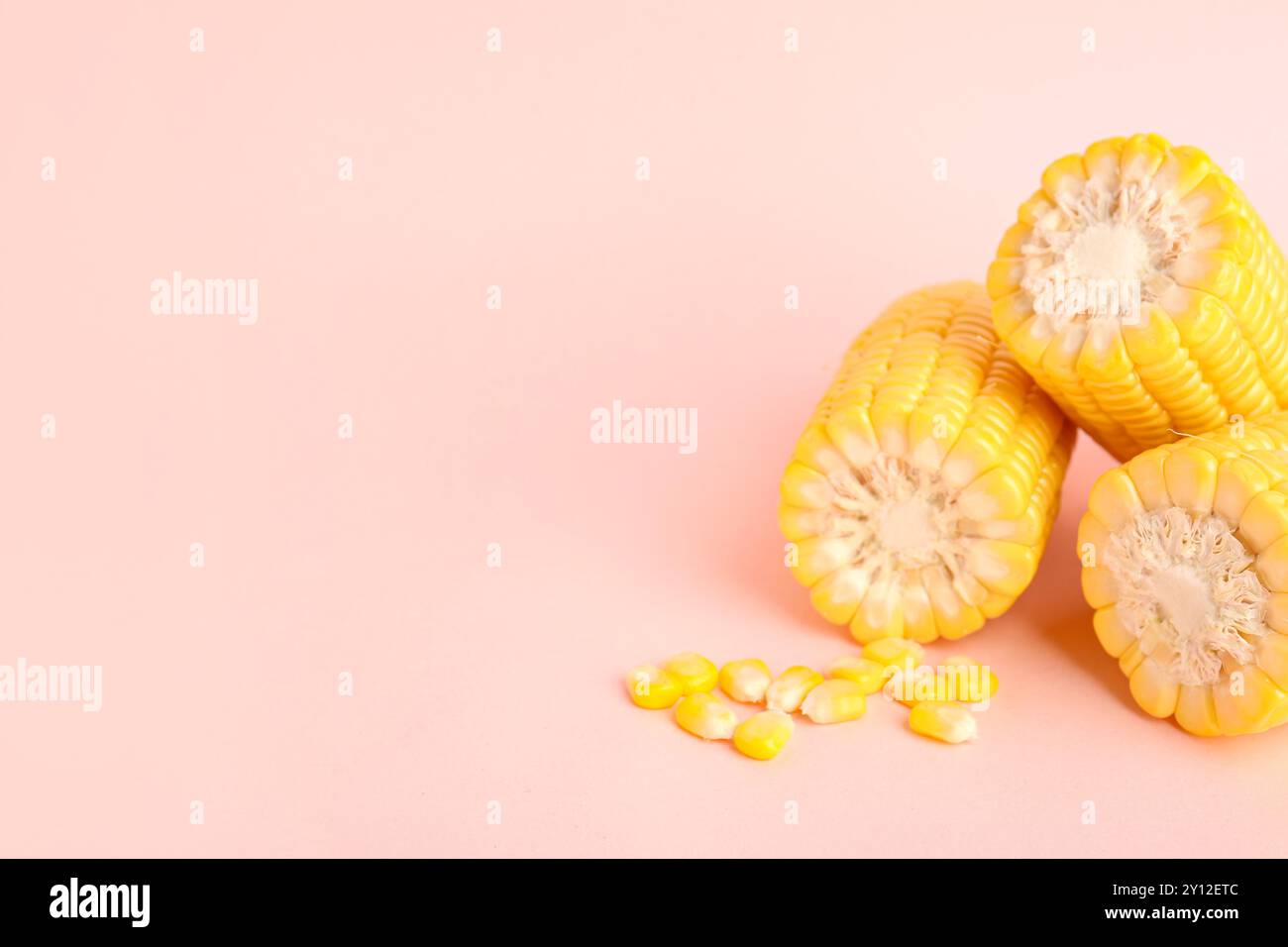 Cut fresh corn cobs and seeds on pink background Stock Photo