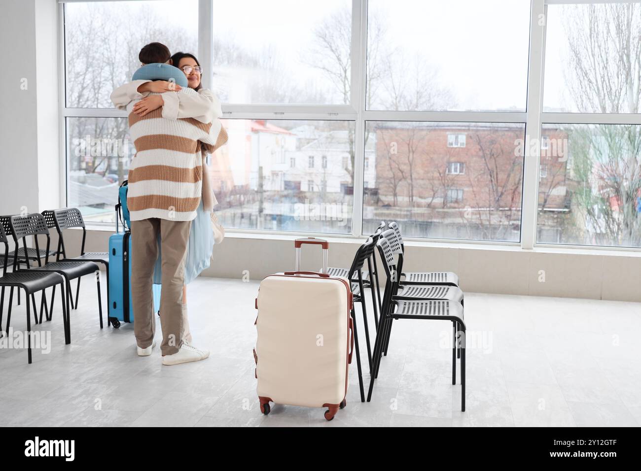 Couple of tourists hugging at airport Stock Photo - Alamy