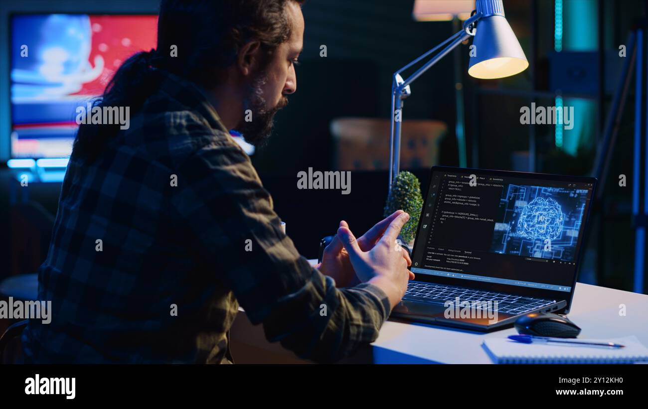 Data scientist updating artificial intelligence neural networks, writing complex binary code scripts. Teleworking freelancer in apartment office uses digital device programming to upgrade AI, camera A Stock Photo