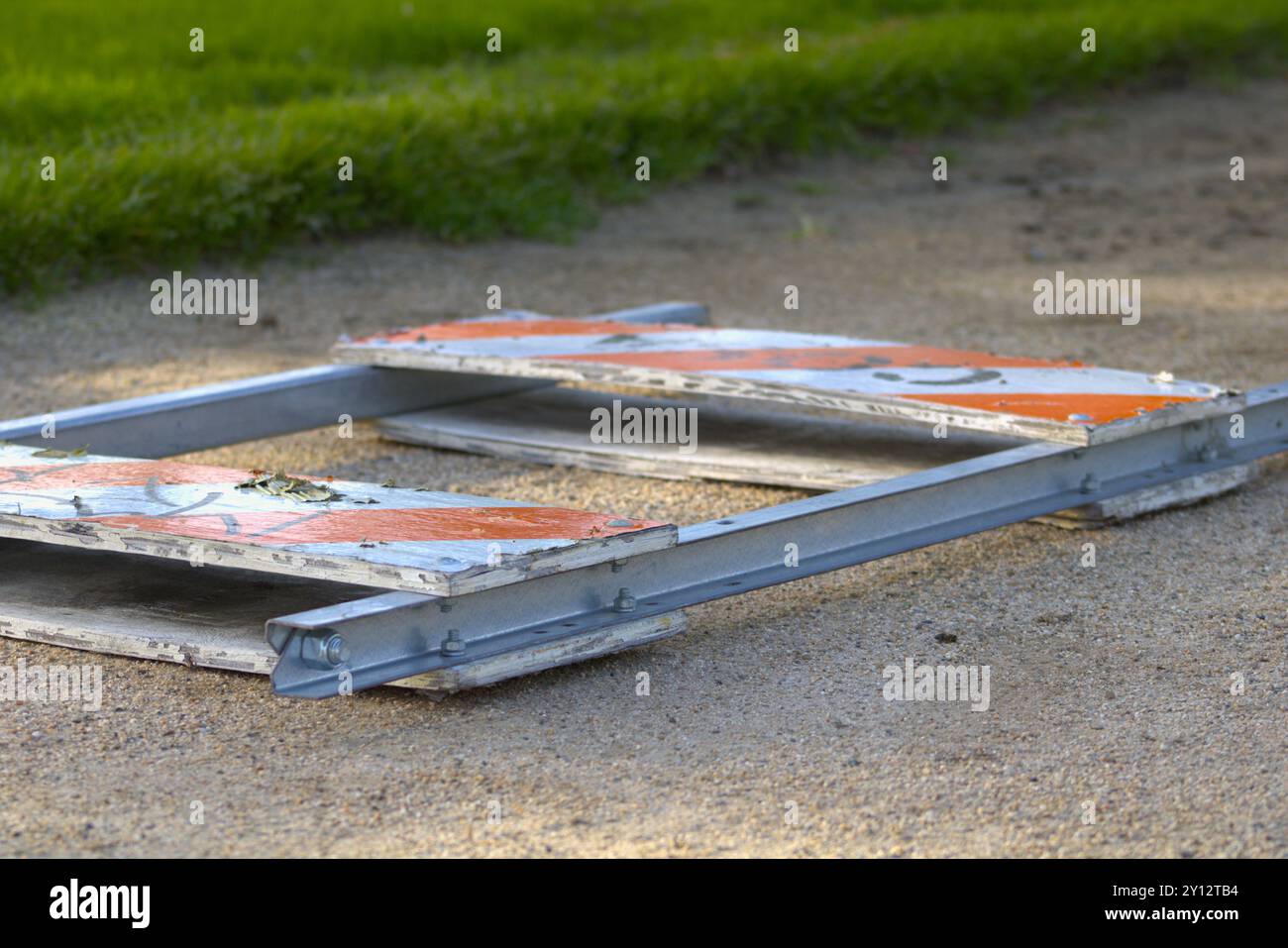 orange and white caution sign closed laying on pathway Stock Photo