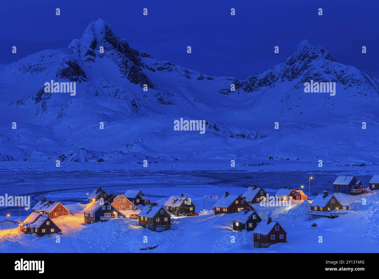 Inuit settlement, houses in deep snow in front of mountains, blue hour ...