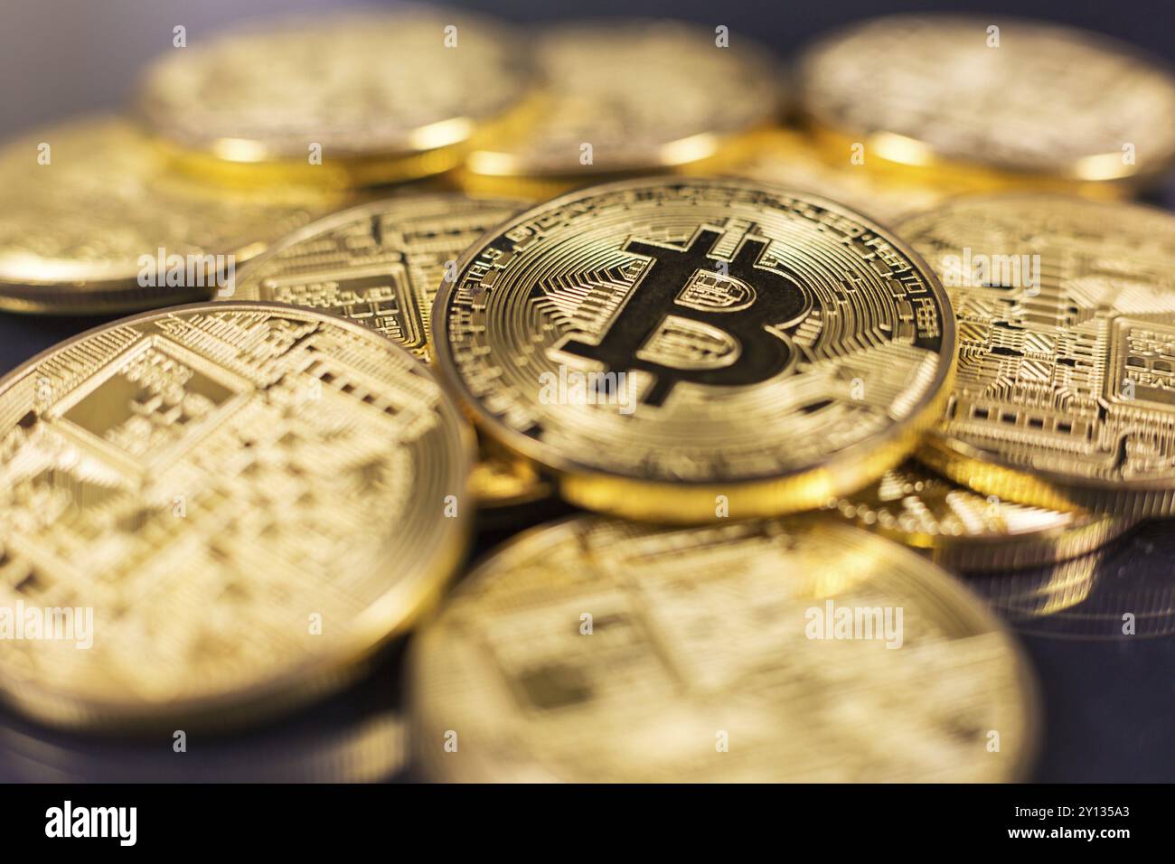 Stack of bitcoins lying on shiny dark surface Stock Photo