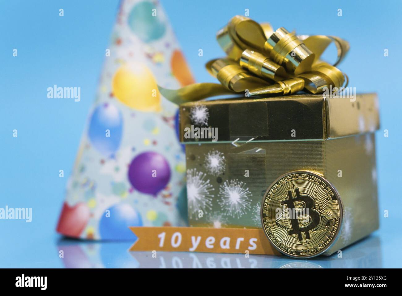 Bitcoin cryptocurrency celebrating birthday - 10 years, coin with birthday  hat behind it, with yellow copy space Stock Photo - Alamy