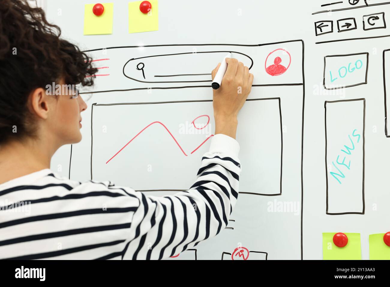 Developing UI design. Woman drawing website wireframe on whiteboard indoors Stock Photo