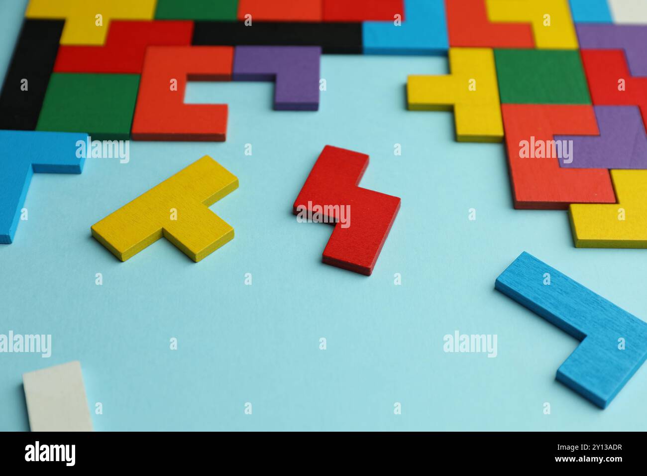 Colorful wooden puzzle pieces on light blue background Stock Photo - Alamy