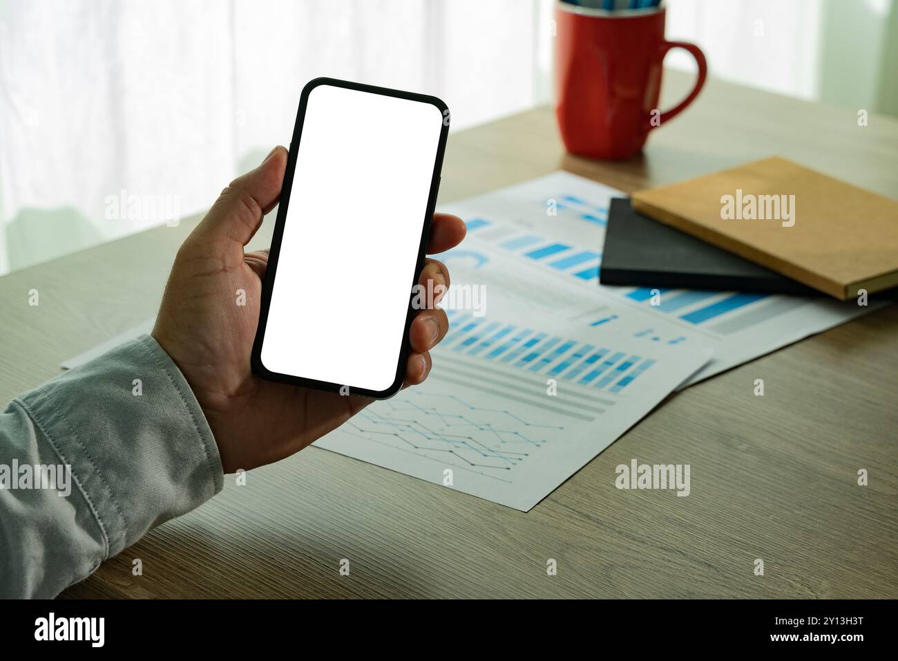 Top view Mockup image hand using a smartphone man Holding Cell Phone With Blank Screen Stock Photo
