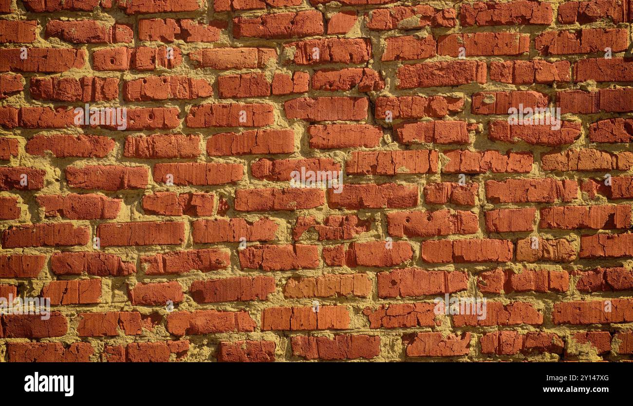 An old scratched red brick wall background. Close up. Stock Photo