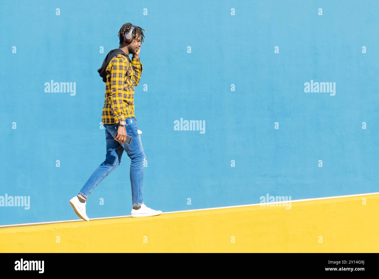 young black man with headphones walking Stock Photo