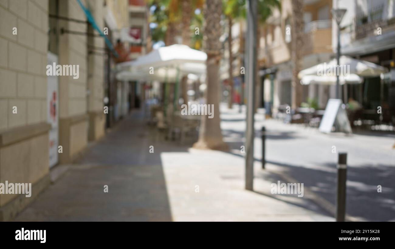 Defocused street scene showing blurred outdoor cafes and palm trees in ...