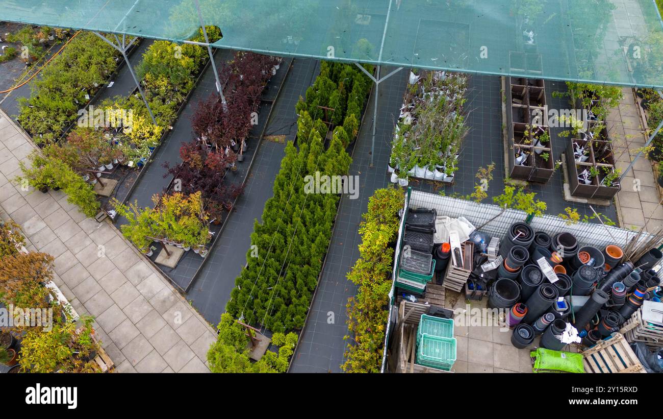 Aerial view of a landscaped nursery with various plants and trees under protective netting. Pathways divide sections of greenery, showcasing a variety Stock Photo