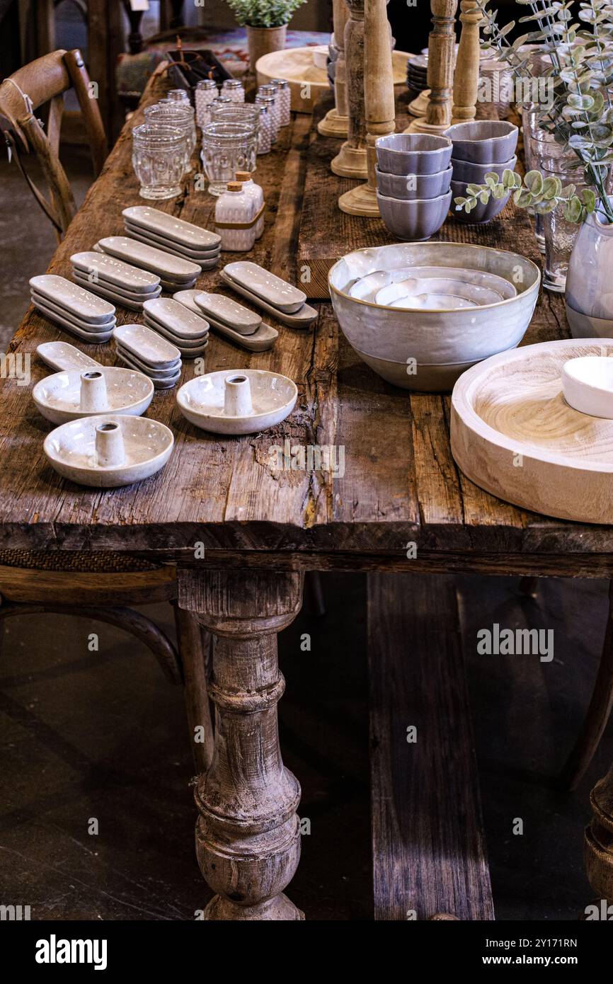 Closeup of Wooden Farmhouse Table with Farmhouse Style Dishes and Serveware in Thanksgiving Setting Stock Photo