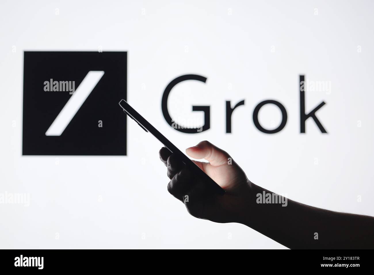 In this photo illustration, the Grok AI logo seen in the background