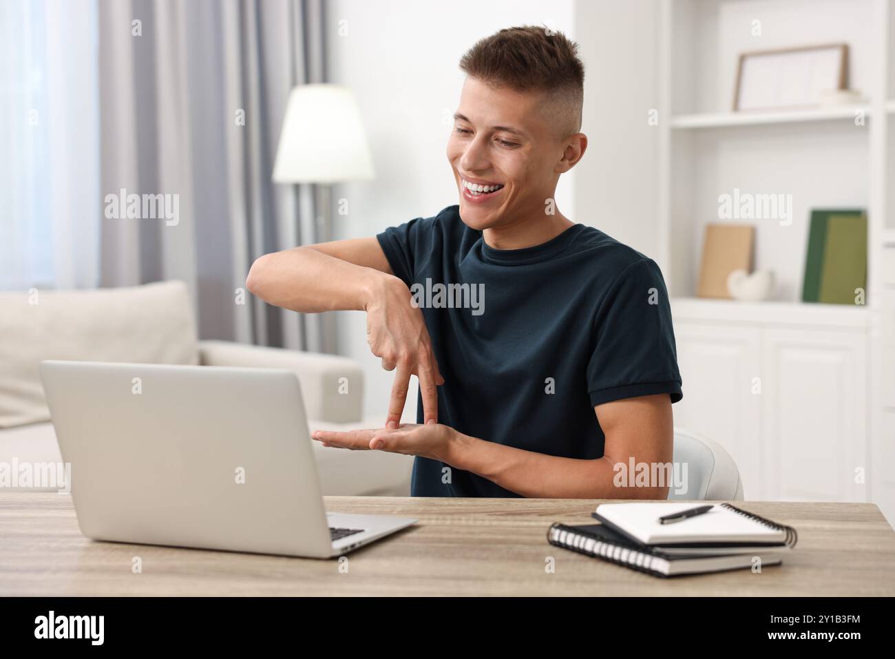 Young man using sign language during video call indoors Stock Photo