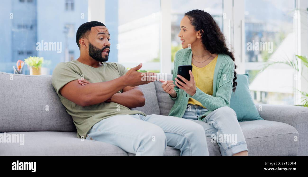 Phone, affair and couple with argument on sofa in living room for divorce, cheating or breakup. Cellphone, upset and young man and woman fighting for Stock Photo