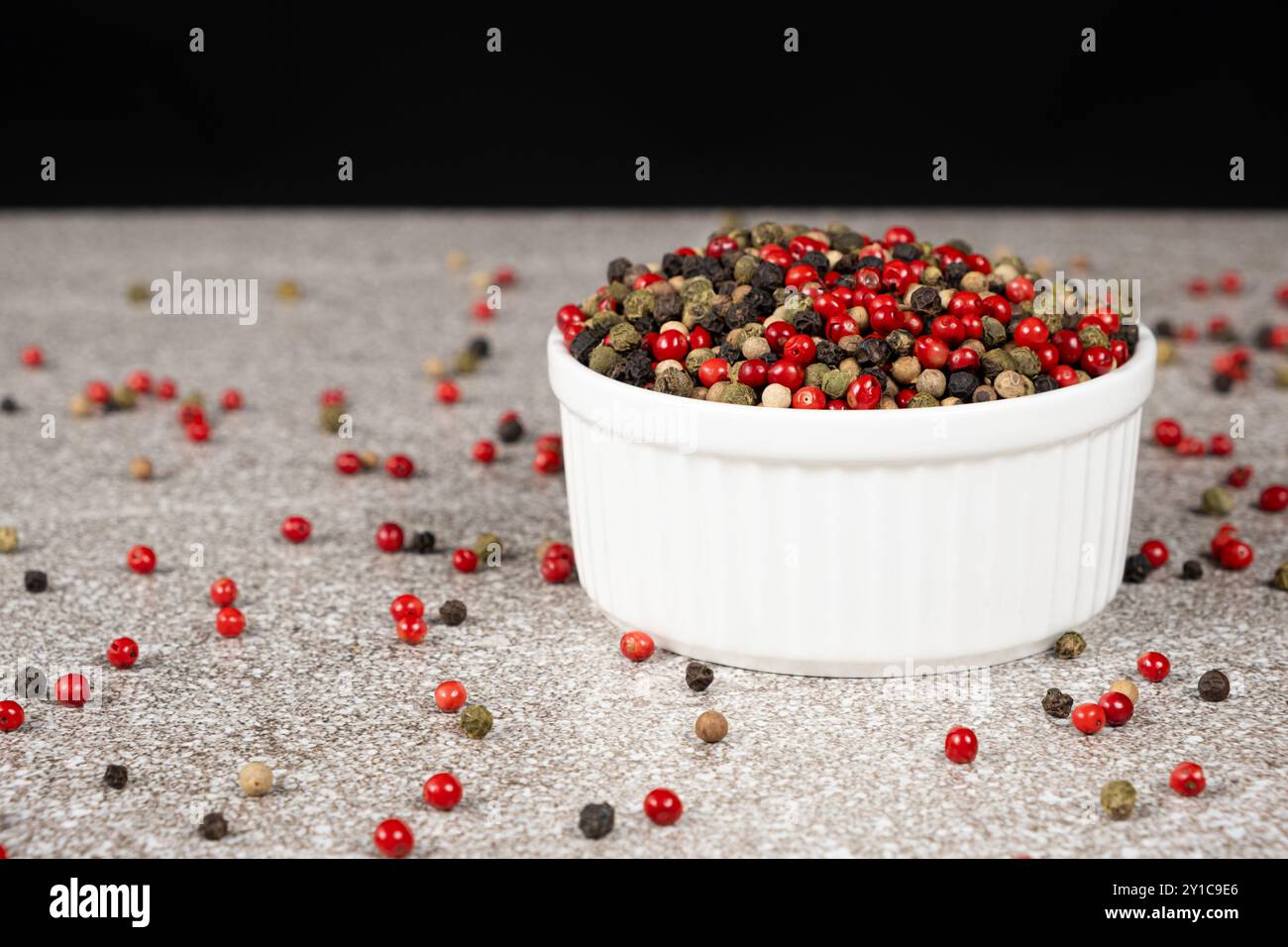 Multicolored peppercorns on a stone gray background Stock Photo