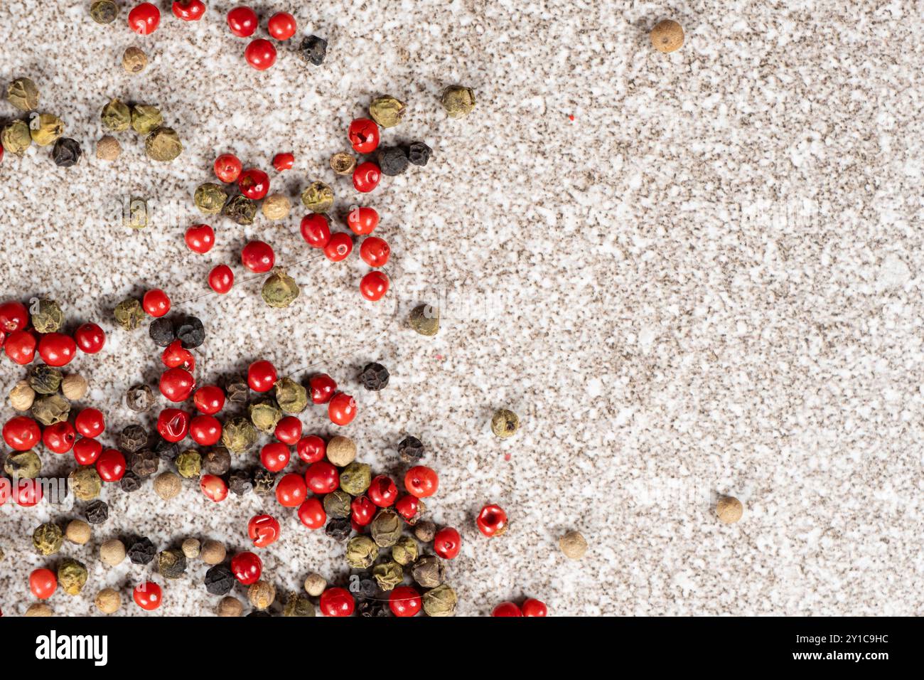 Multicolored peppercorns on a stone gray background Stock Photo
