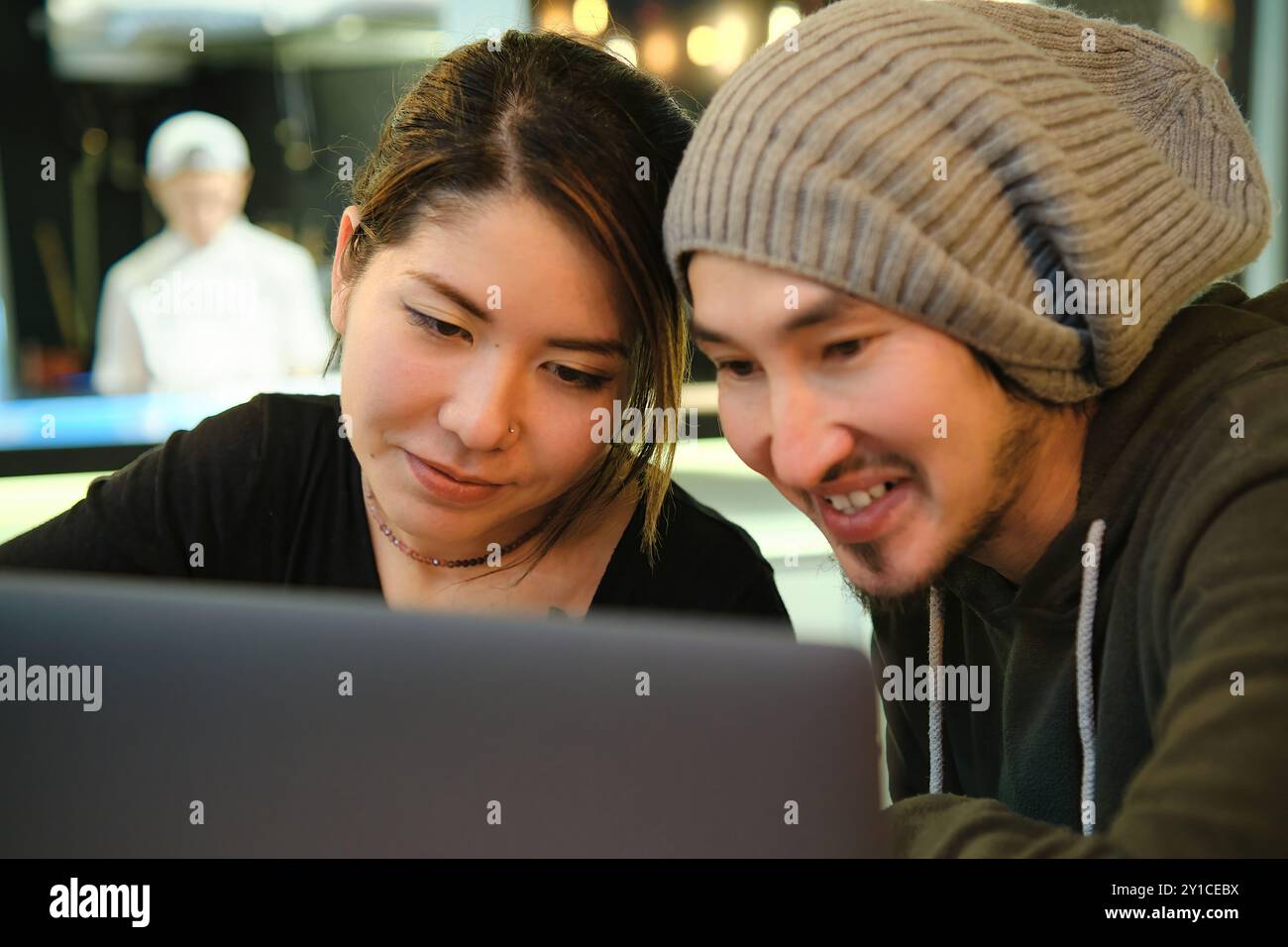 Asian couple sitting at a table in a restaurant and working with Stock Photo