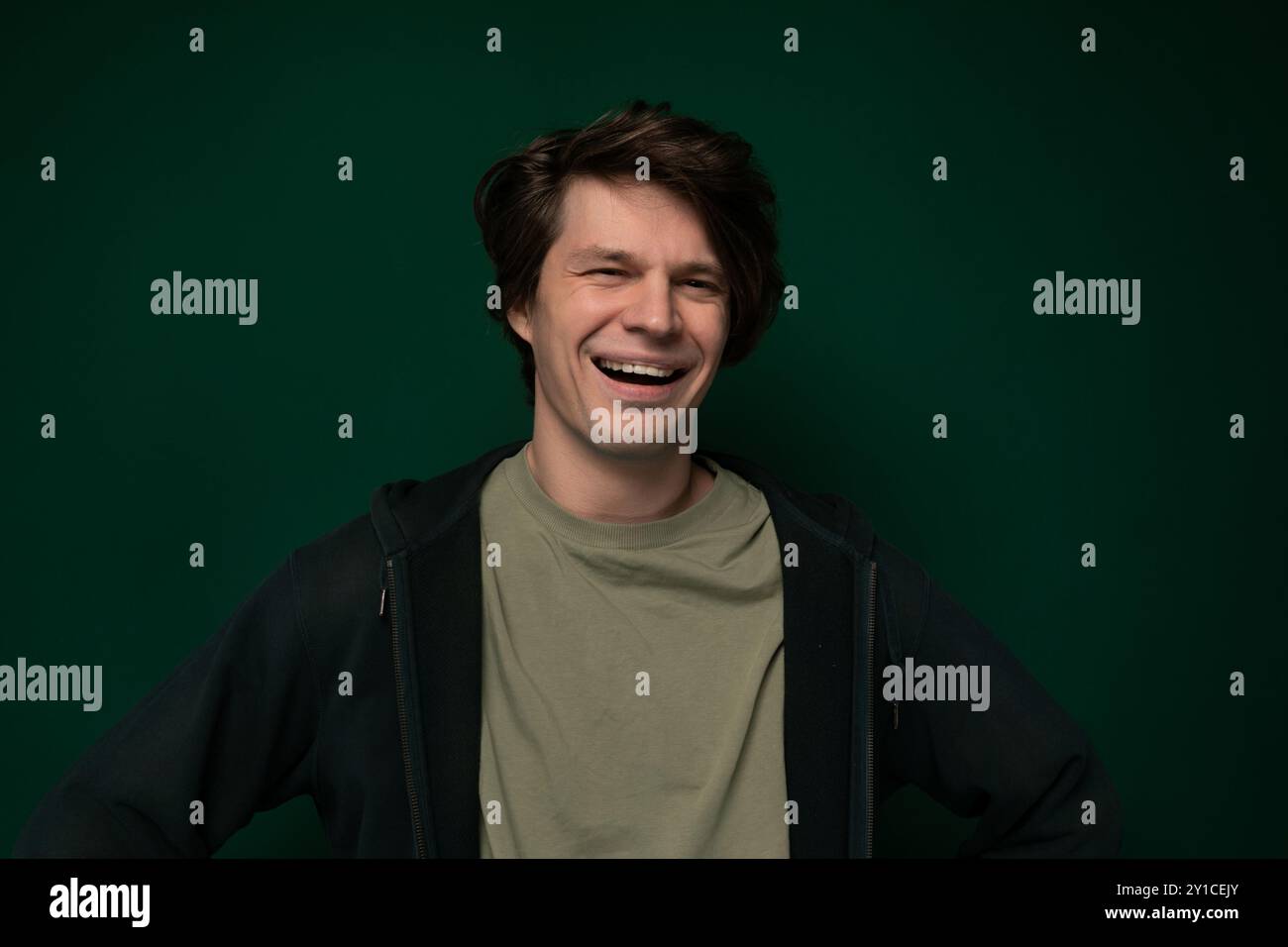 Man Smiling in Front of Green Wall Stock Photo - Alamy