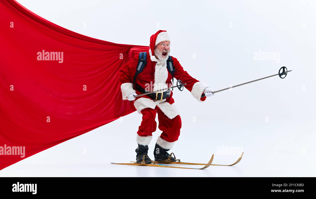 Santa Claus, smiling excitedly, holding steering wheel while skiing ...