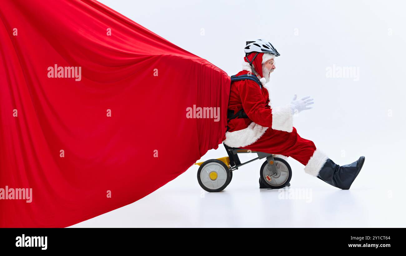 Santa Claus on child's tricycle, holding huge, heavy red bag of gifts ...