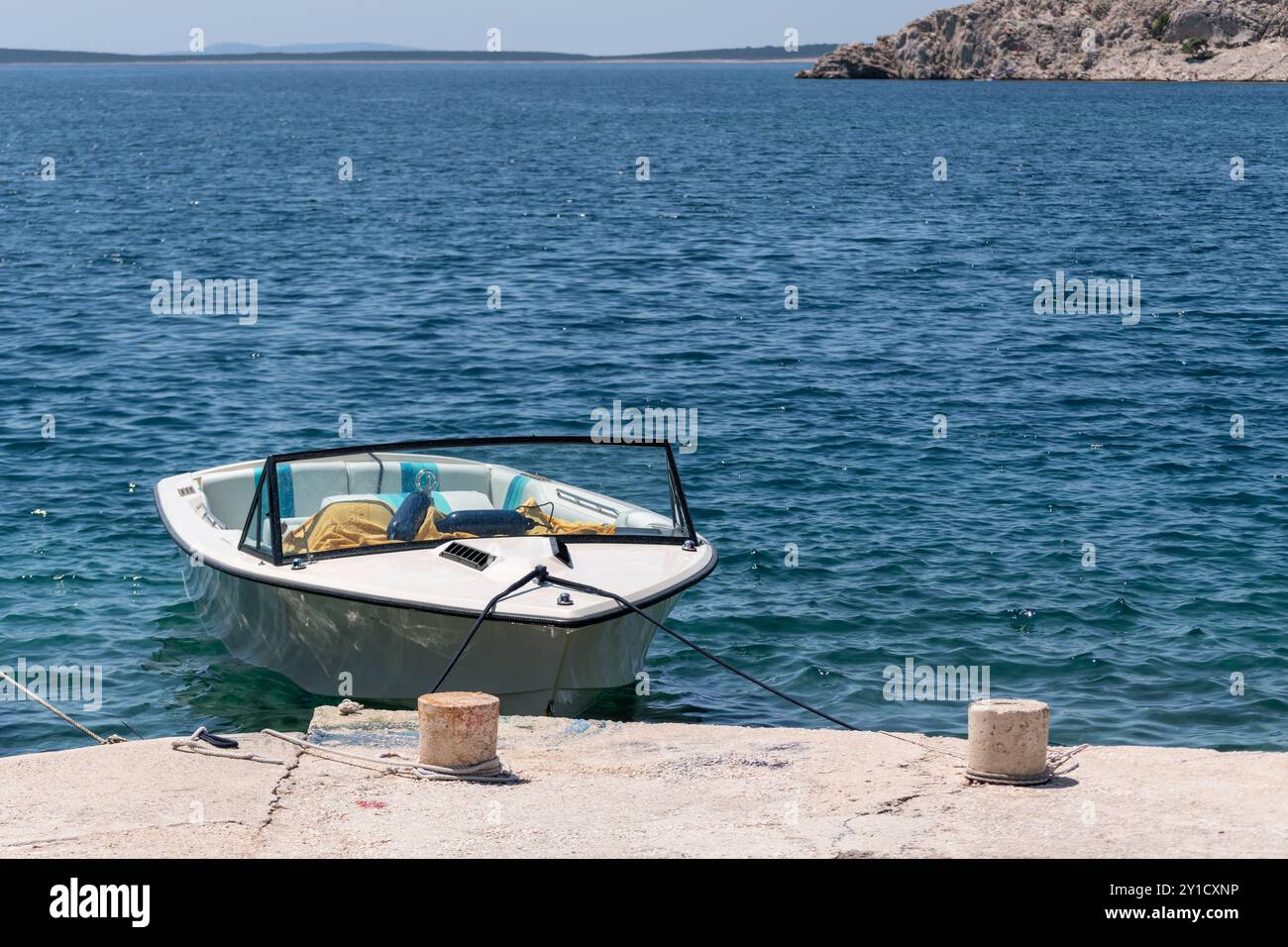 Moored boat at concrete dock Stock Photo - Alamy