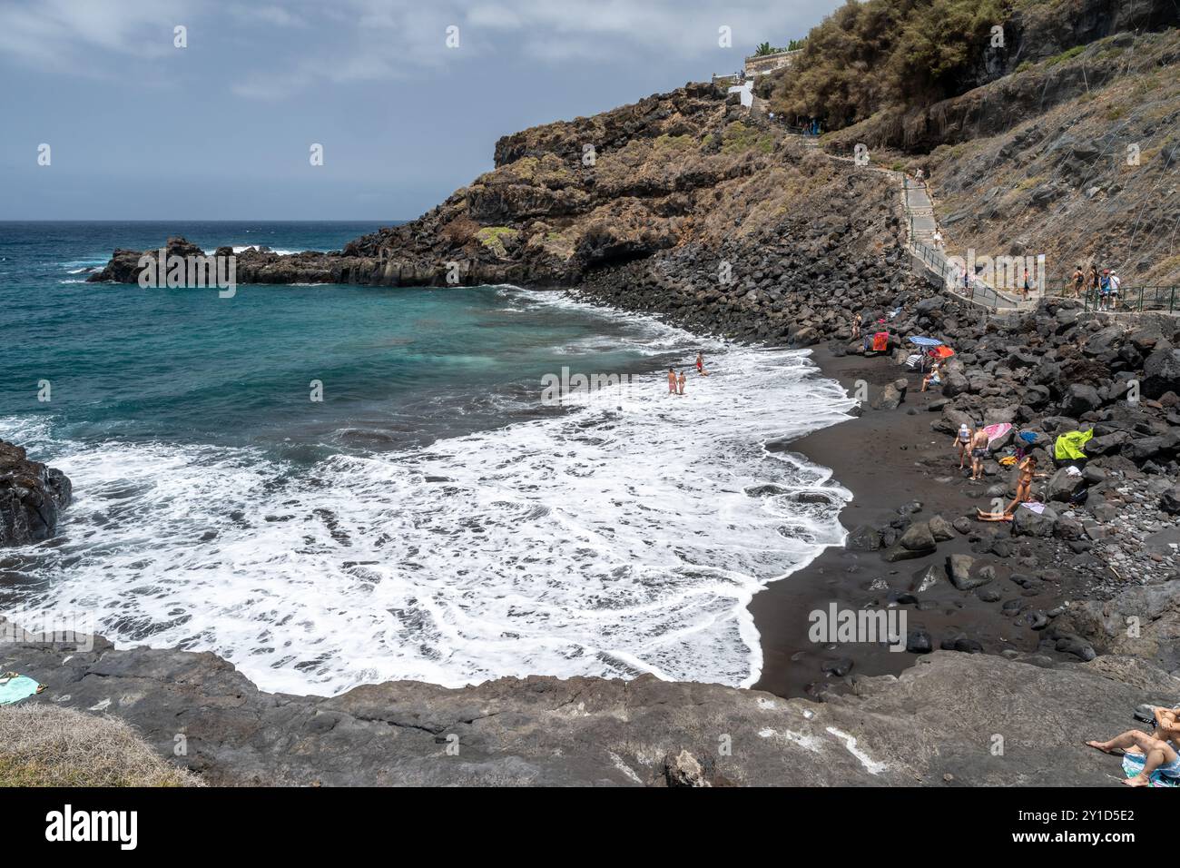 Stunning Coastal View Of Goyuyo Beach With Black Sand Visitors And stunning-coastal-view-of-goyuyo-beach-with-black-sand-visitors-and