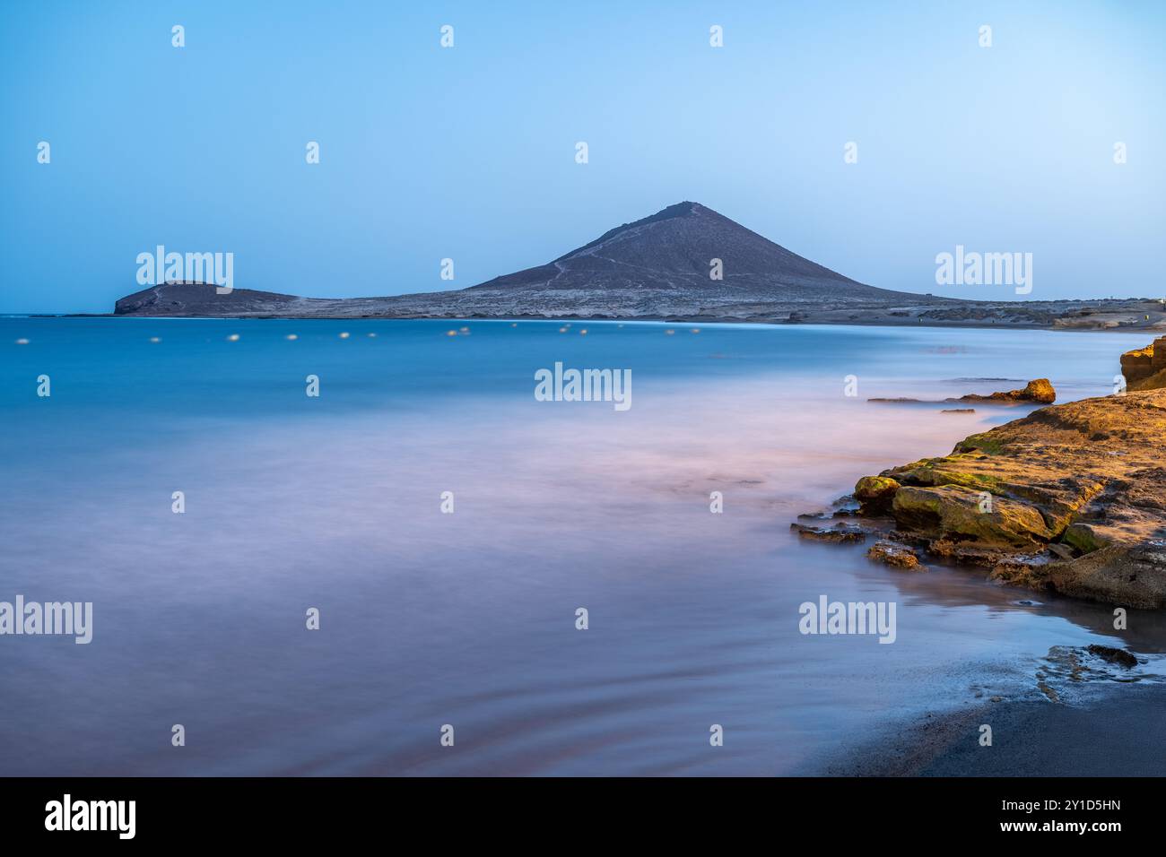 Long exposure photo of Costa de El Medano with Montana Roja in the background during twilight, Granadilla de Abona, Tenerife, Canary Islands, Spain. Stock Photo