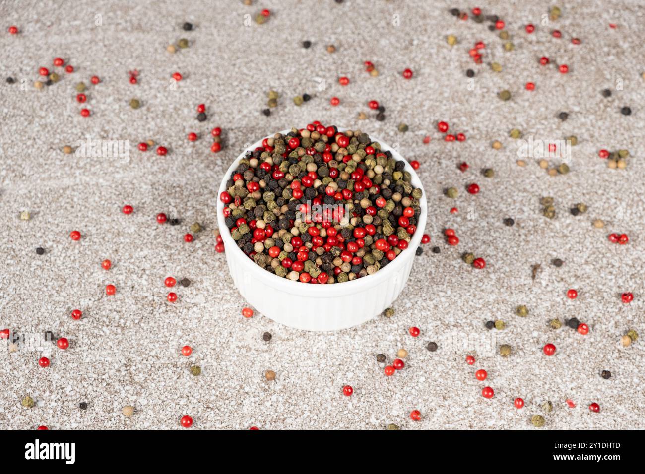 Multicolored peppercorns on a stone gray background. Stock Photo