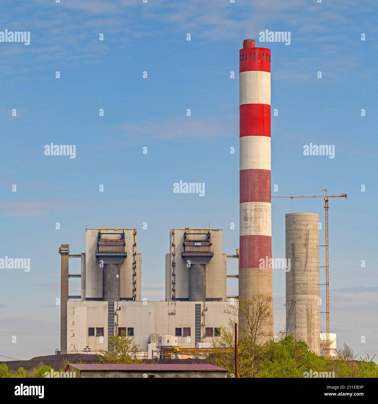 Obrenovac, Serbia - April 04, 2024: Red and White Chimney at Thermal Power Plant Facility Station Spring Day. Stock Photo