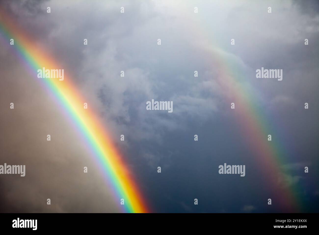 Rainbow in blue sky with white clouds hi-res stock photography and ...