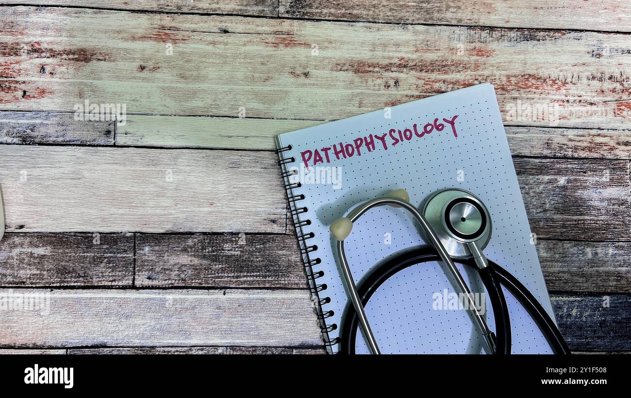 Concept of Pathophysiolgy write on book isolated on Wooden Table. Stock Photo