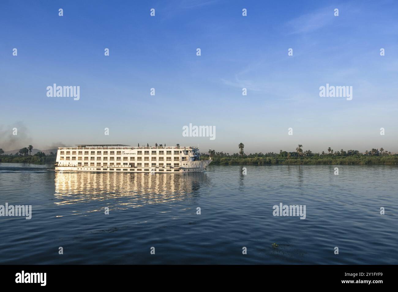 This powerful photograph captures the stark contrast between leisure and industry along the Nile, a juxtaposition that prompts contemplation about the Stock Photo