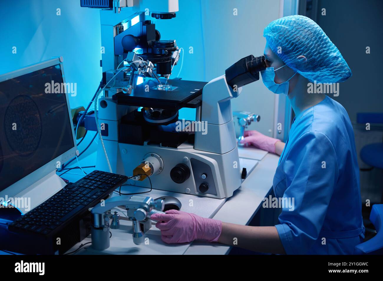 Laboratory worker using modern microscope in mask and gloves hi-res ...