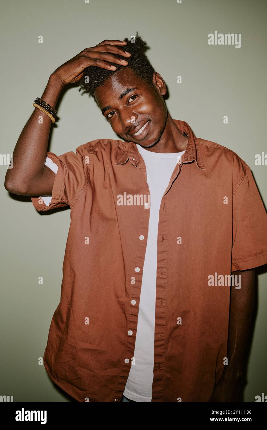 Black man touching his black hair while posing for portrait Stock Photo