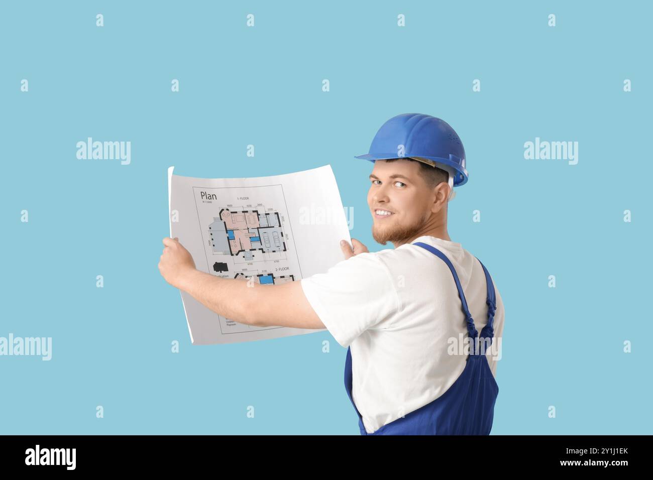 Male contractor with house plan on blue background Stock Photo - Alamy