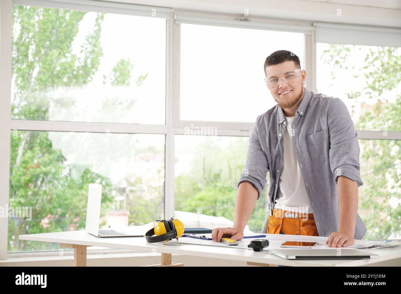 Male contractor working at table in room Stock Photo