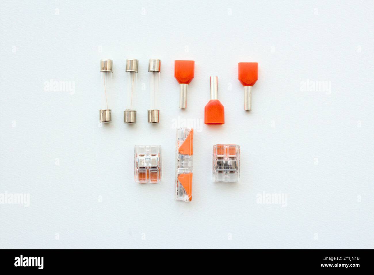 Electrical cable and wiring components, including accessories like fuses, terminals, wire splice connectors isolated on white background. Stock Photo