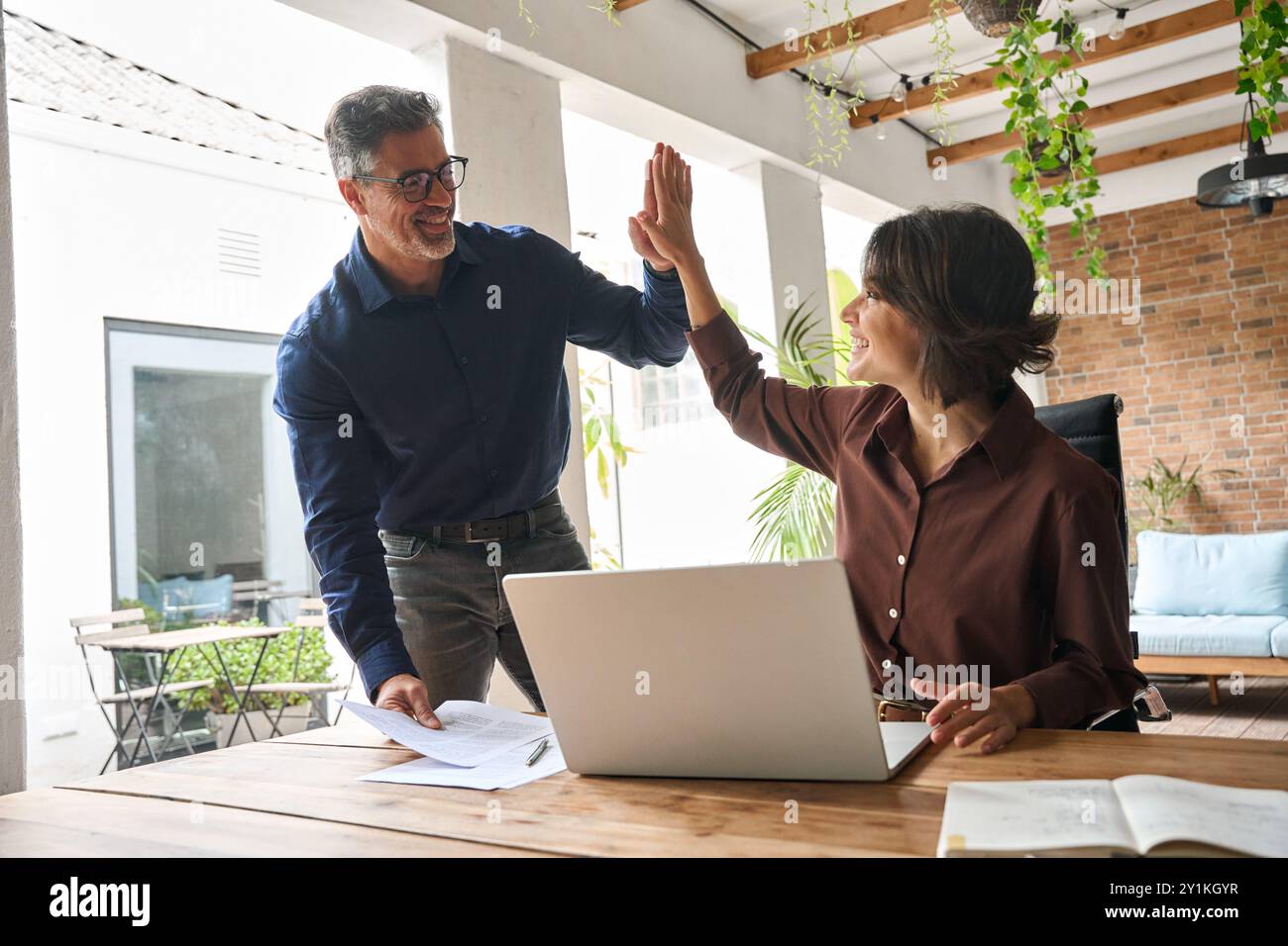 Two happy professional business team people man and woman giving high ...