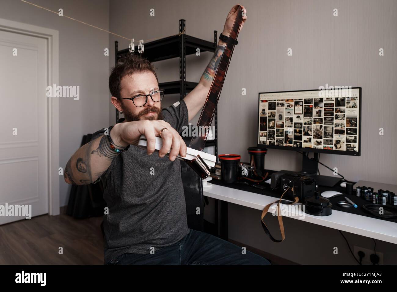 Photographer reviewing film negatives at a modern workstation Stock Photo
