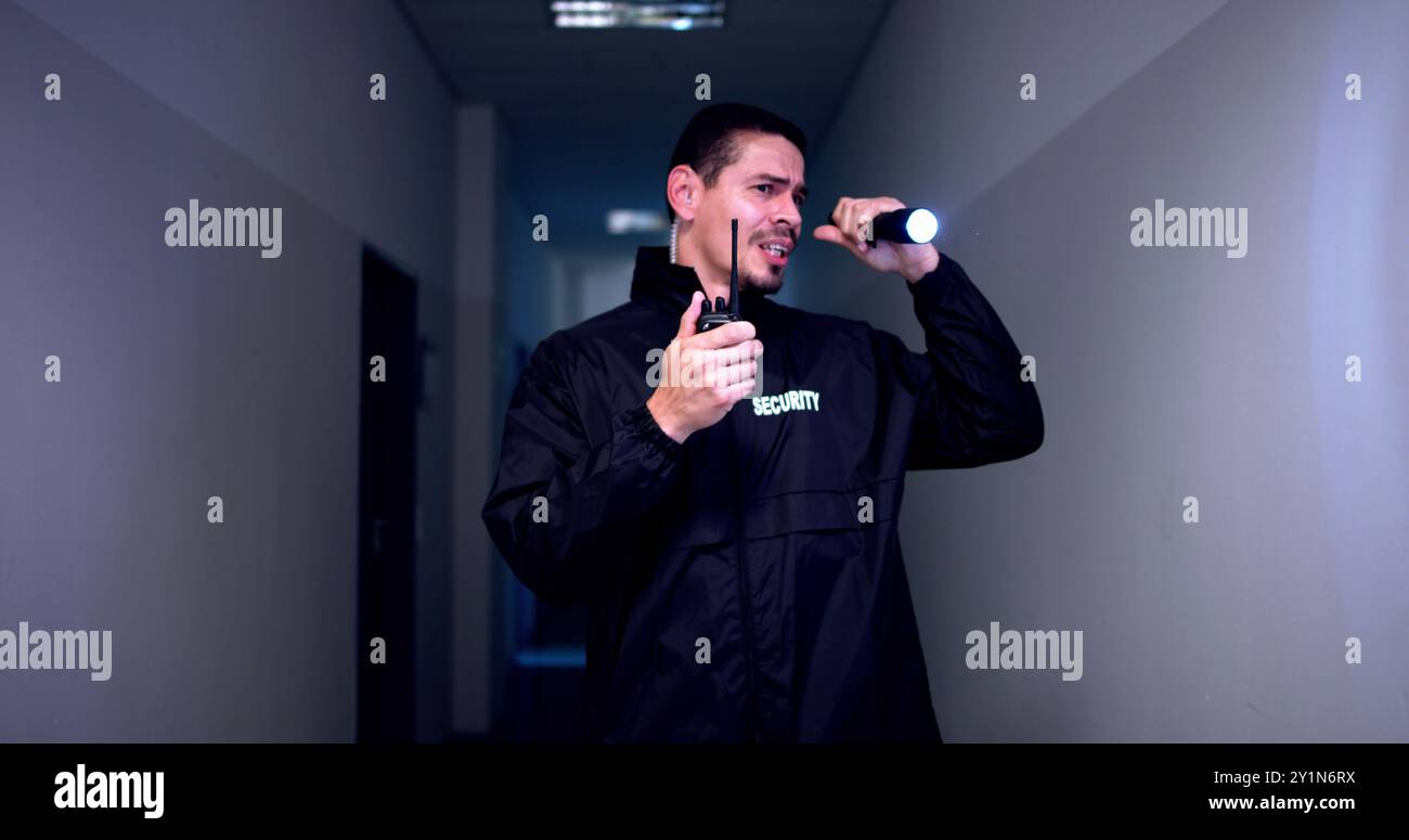 Male Security Guard With Flashlight At Night Stock Photo